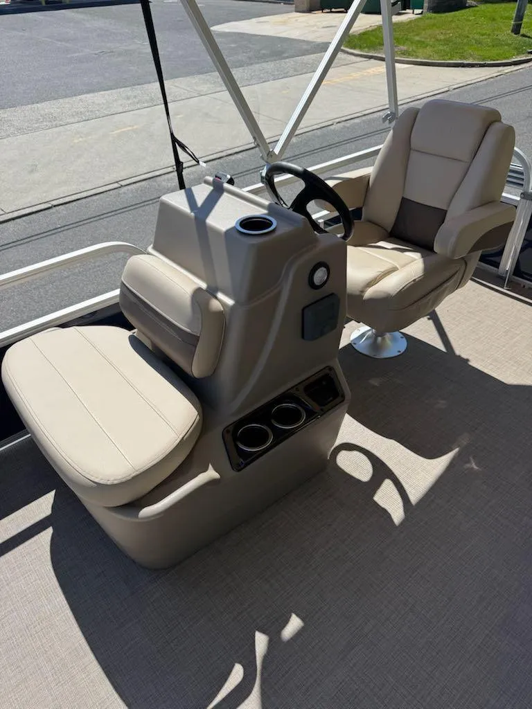 Slide: The Image of 2025 Sun Tracker Bass Buggy 16 XL Select interior with beige seating and steering console. - 9
