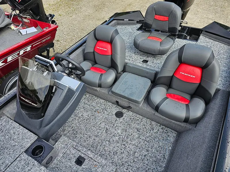Slide: The Image of 2025 Tracker Pro Team 175 boat interior with gray and red seating, steering console, and carpeted flooring. - 10