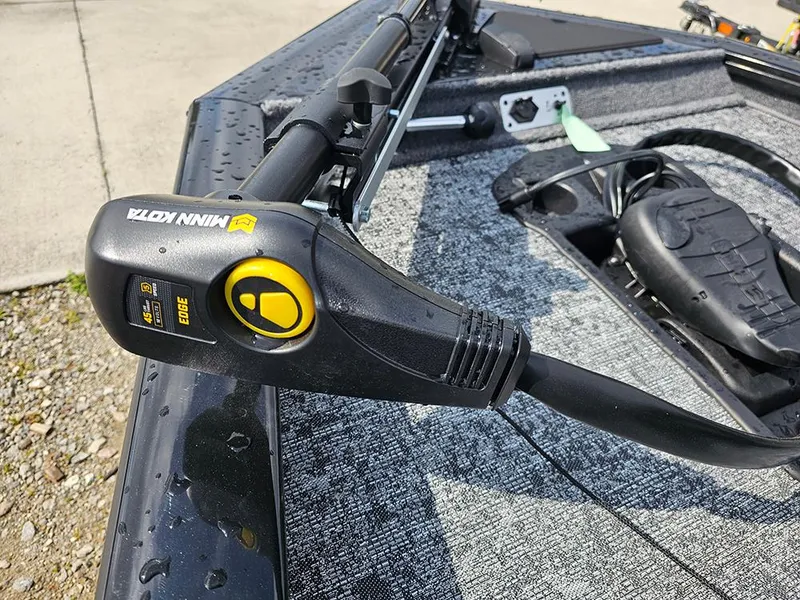 Slide: The Image of 2025 Tracker Pro Team 175 boat with Minn Kota trolling motor, wet from recent use. - 17