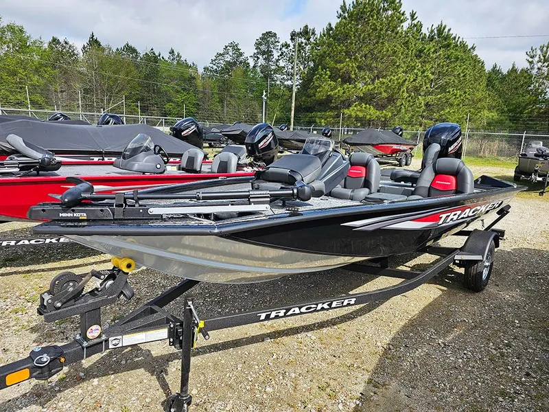 Slide: The Image of 2025 Tracker Pro Team 175 boat on trailer, parked outdoors with trees in background. - 6