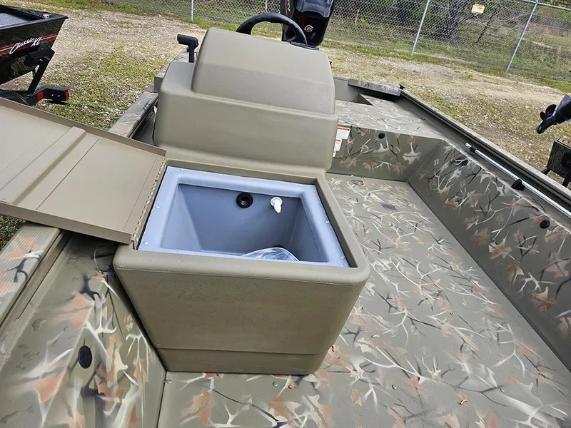 Slide: The Image of 2025 Tracker Grizzly 1648 SC boat with open storage compartment, camo design, and steering console. - 10