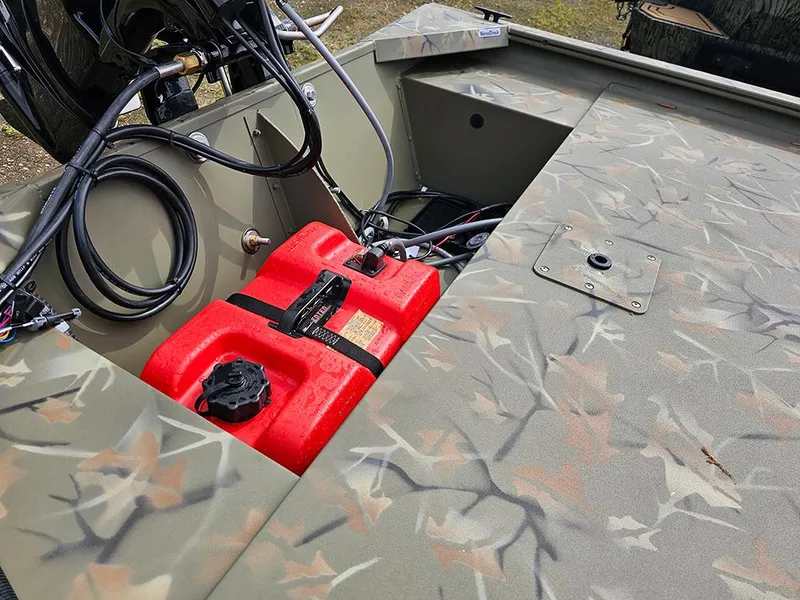Slide: The Image of 2025 Tracker Grizzly 1648 SC boat interior with camouflage design and red fuel tank. - 13