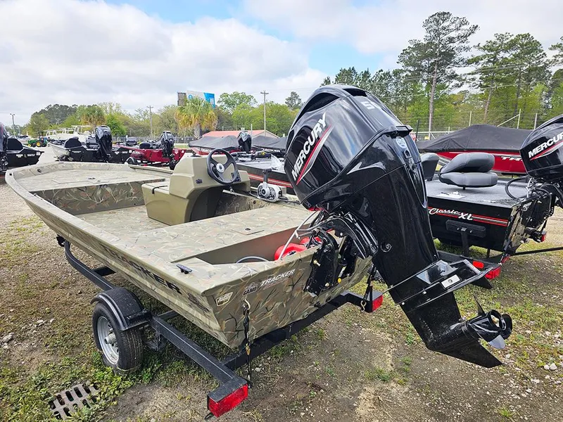 Slide: The Image of 2025 Tracker Grizzly 1648 SC boat with Mercury engine on trailer, parked outdoors. - 3