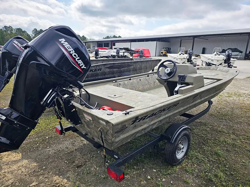 Slide: The Image of 2025 Tracker Grizzly 1648 SC boat with Mercury engine on trailer, parked outdoors. - 4