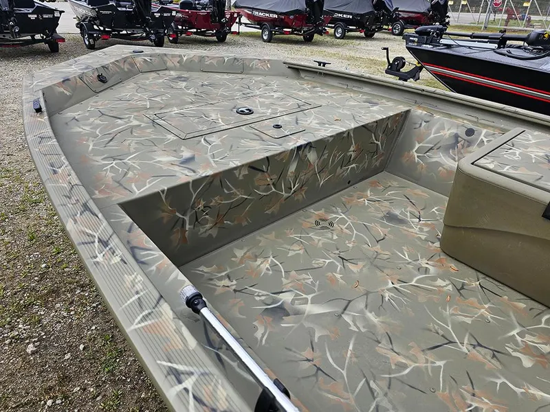 Slide: The Image of 2025 Tracker Grizzly 1648 SC boat with camouflage interior, parked outdoors. - 8