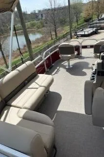 Slide: The Image of 2025 Sun Tracker Bass Buggy 16 XL Select pontoon boat with spacious seating and scenic lake view. - 4