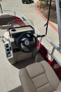 Slide: The Image of 2025 Sun Tracker Bass Buggy 16 XL Select pontoon boat interior with steering wheel and seating. - 7