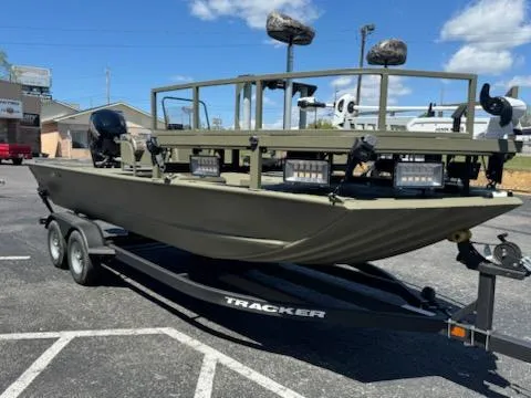Slide: The Image of 2025 Tracker Grizzly 2072 CC Sportsman boat on trailer, parked outdoors. - 2