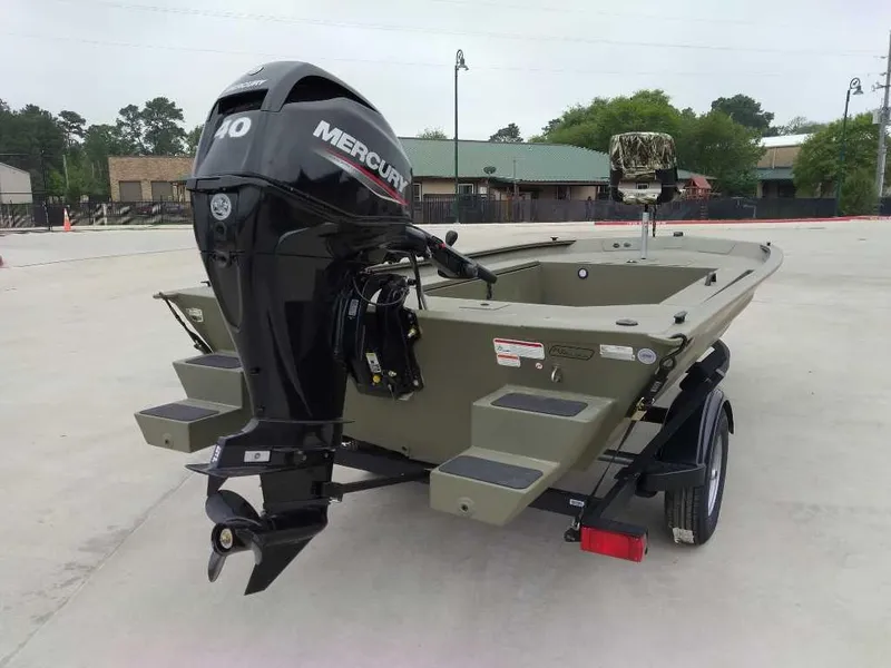 Slide: The Image of 2025 Tracker Grizzly 1654 T Sportsman boat with Mercury engine, parked outdoors. - 3