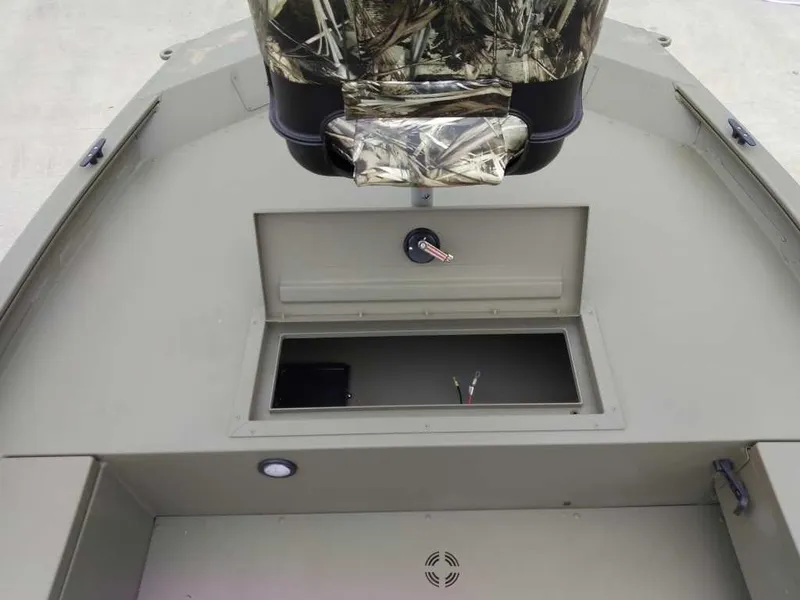 Slide: The Image of 2025 Tracker Grizzly 1654 T Sportsman boat interior with storage compartment and camo seat. - 6