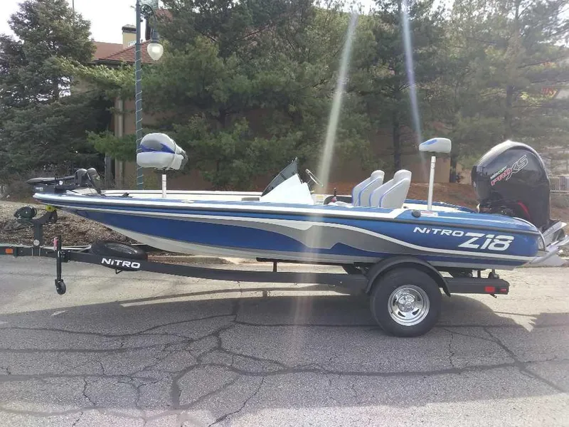 The Image of 2025 Nitro Z18 boat on trailer, blue and white design, parked outdoors. - 0