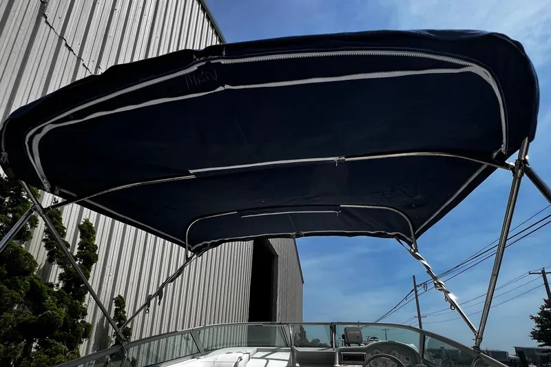 Slide: The Image of 2000 Formula 260 Sun Sport boat with blue canopy under clear sky. - 6