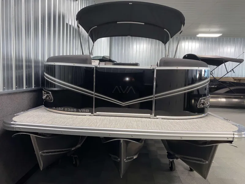 Slide: The Image of 2025 Avalon LSZ 2385 VRB Tritoon boat in showroom, black exterior, sleek design. - 15