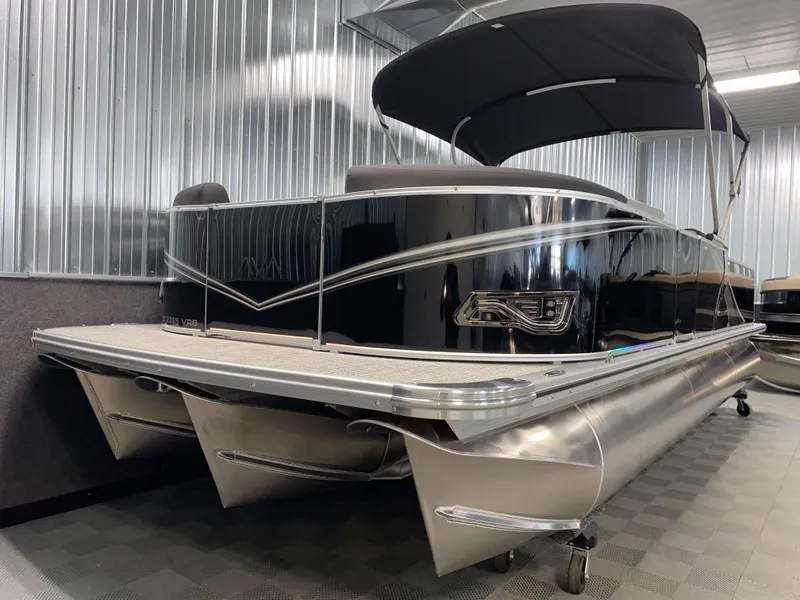 Slide: The Image of 2025 Avalon LSZ 2385 VRB Tritoon boat with sleek black design and canopy. - 16