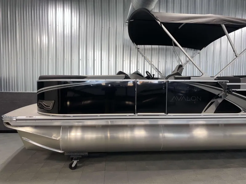Slide: The Image of 2025 Avalon LSZ 2385 VRB Tritoon with black exterior and canopy in showroom. - 17