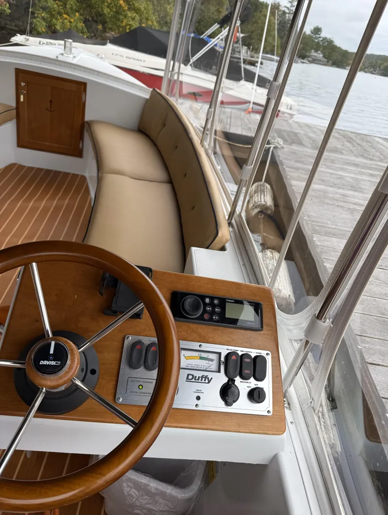 Slide: The Image of 2022 Duffy Back Bay 16 boat interior with steering wheel and control panel at dock. - 13