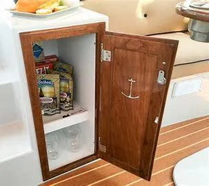 Slide: The Image of Wooden cabinet on 2022 Duffy Back Bay 16 boat, open to reveal snacks and glasses. - 14