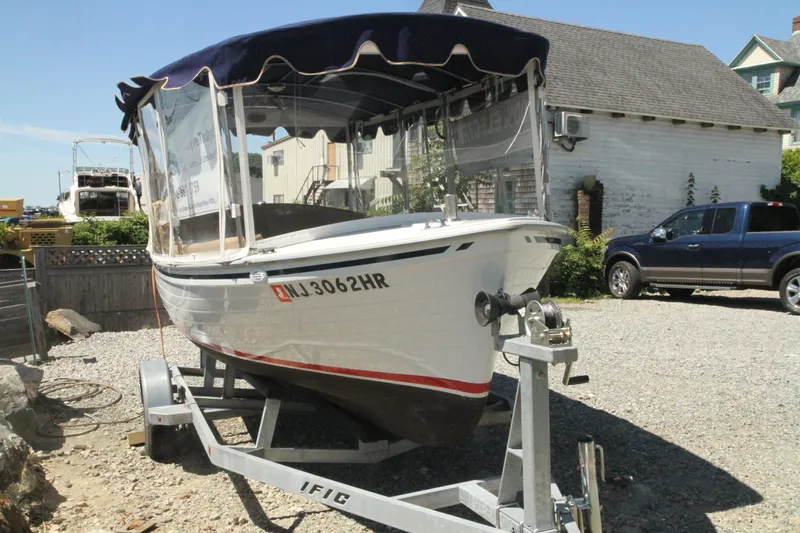 Slide: The Image of 2022 Duffy Back Bay 16 boat on trailer in a sunny yard. - 2