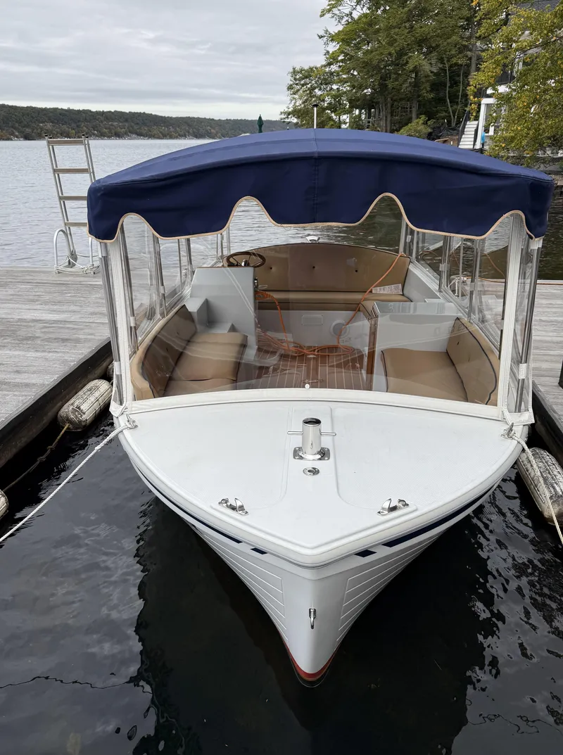 Slide: The Image of 2022 Duffy Back Bay 16 electric boat docked by a serene lake. - 5