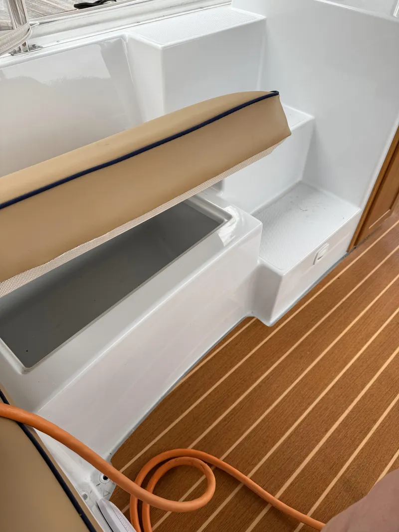 Slide: The Image of 2022 Duffy Back Bay 16 boat interior with storage compartment and wooden flooring. - 9