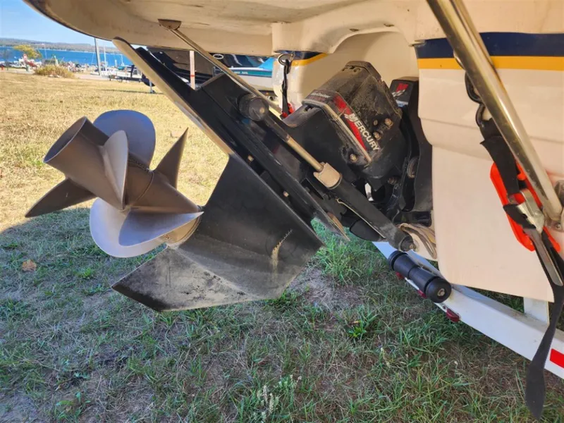 Slide: The Image of 2003 Chaparral 260 SSi boat propeller and outdrive on grassy shore. - 12