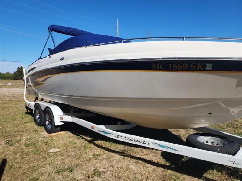 Slide: The Image of 2003 Chaparral 260 SSi boat on trailer, parked on grass under clear blue sky. - 14