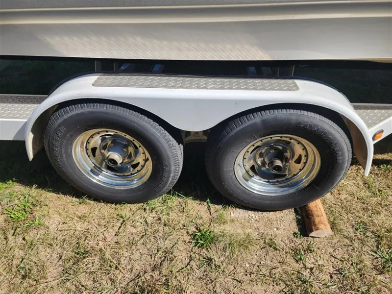 Slide: The Image of Trailer wheels of a 2003 Chaparral 260 SSi boat on grass. - 15