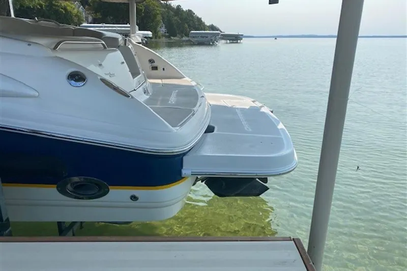 Slide: The Image of 2003 Chaparral 260 SSi boat docked on calm lake water. - 18