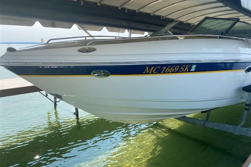 Slide: The Image of 2003 Chaparral 260 SSi boat docked on clear water under a covered slip. - 20