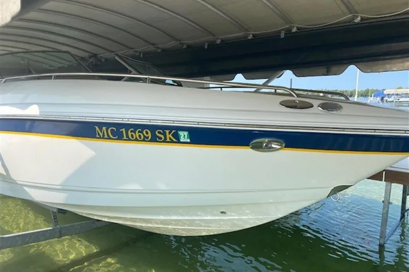 Slide: The Image of 2003 Chaparral 260 SSi boat docked under a canopy, side view. - 21