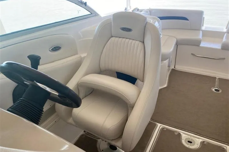 Slide: The Image of 2003 Chaparral 260 SSi boat interior with white captain's chair and steering wheel. - 22