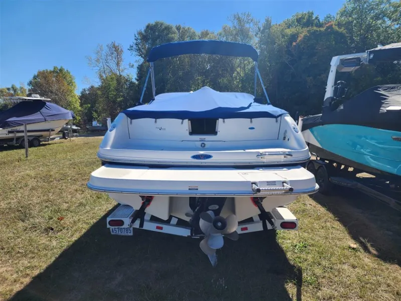 Slide: The Image of 2003 Chaparral 260 SSi boat with blue cover, parked on grass. - 6