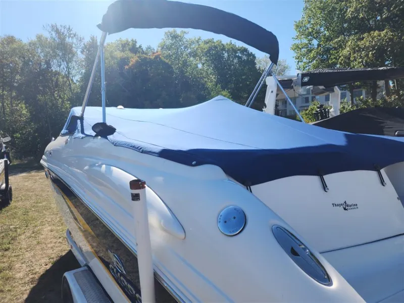 Slide: The Image of 2003 Chaparral 260 SSi boat with blue cover, parked outdoors on a sunny day. - 8