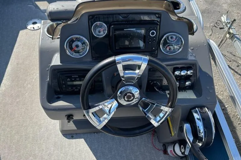 Slide: The Image of Steering console of 2020 Tahoe Pontoon GT Quad Lounger 23' with chrome accents and gauges. - 5