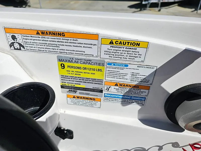 Slide: The Image of Warning labels on 2020 Hurricane SunDeck Sport 185 OB boat, indicating capacity and safety instructions. - 17