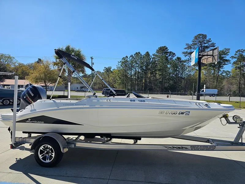 Slide: The Image of 2020 Hurricane SunDeck Sport 185 OB boat on trailer, parked outdoors under clear blue sky. - 5