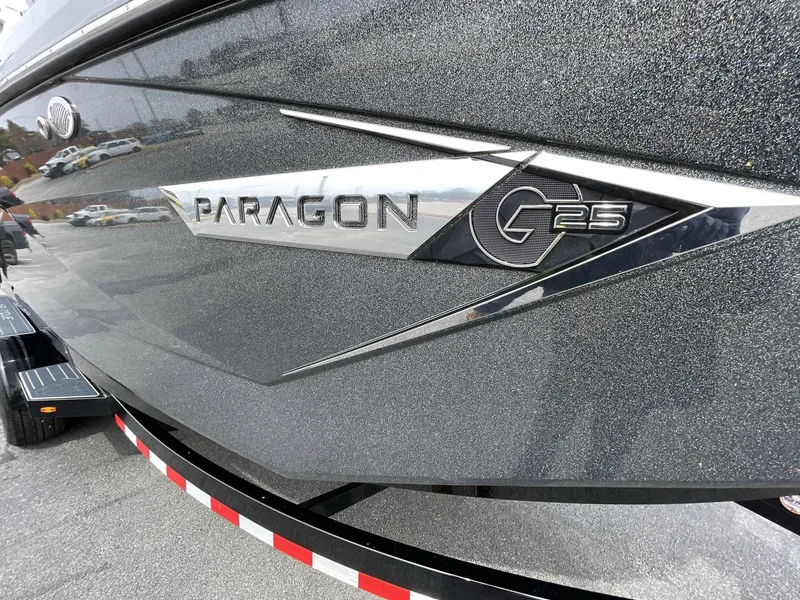 Slide: The Image of 2023 Nautique Super Air Nautique G25 Paragon boat side view with logo detail. - 12