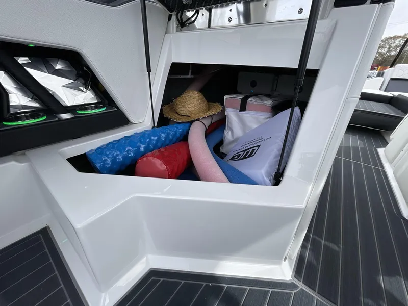 Slide: The Image of 2023 Nautique Super Air Nautique G25 Paragon storage compartment with pool noodles and accessories. - 25