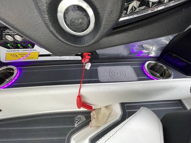 Slide: The Image of Interior of 2023 Nautique Super Air Nautique G25 Paragon with cup holders and wireless charging pad. - 30