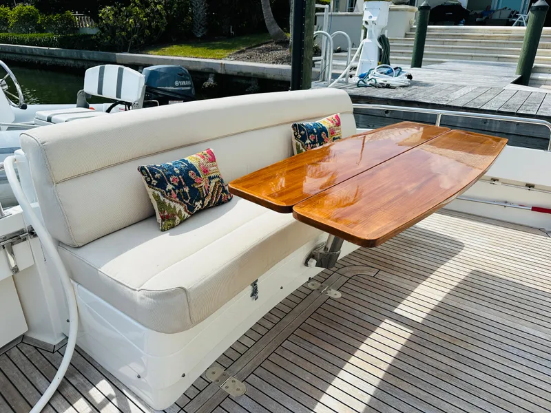 Slide: The Image of Luxurious seating area on 2014 Grand Banks 46 Eastbay SX with wooden table and decorative cushions. - 11