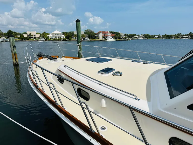 Slide: The Image of 2014 Grand Banks 46 Eastbay SX yacht docked by waterfront homes. - 2