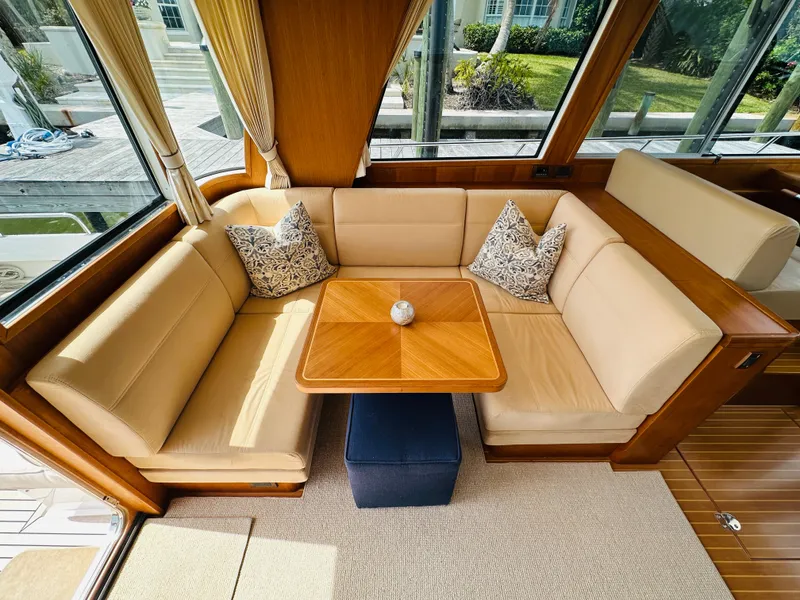 Slide: The Image of Luxurious seating area on 2014 Grand Banks 46 Eastbay SX yacht, featuring elegant cushions and wooden table. - 20