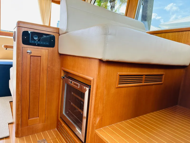Slide: The Image of Interior of 2014 Grand Banks 46 Eastbay SX with wood finish and built-in mini fridge. - 24
