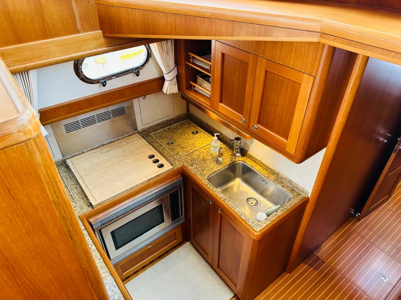 Slide: The Image of Luxurious 2014 Grand Banks 46 Eastbay SX yacht kitchen with wood cabinetry and granite countertops. - 34