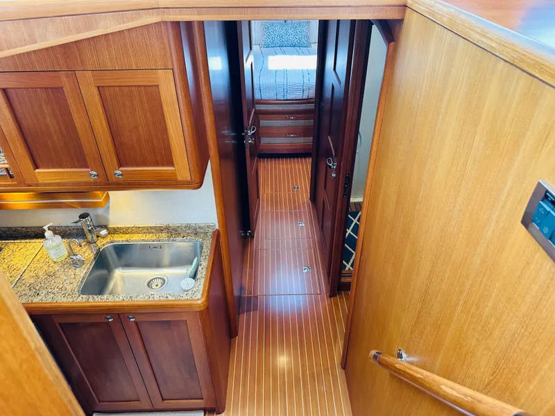 Slide: The Image of 2014 Grand Banks 46 Eastbay SX interior with wooden cabinetry and granite countertop. - 35