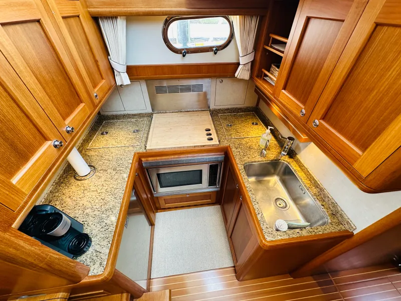 Slide: The Image of Luxurious 2014 Grand Banks 46 Eastbay SX yacht kitchen with wood cabinetry and granite countertops. - 36