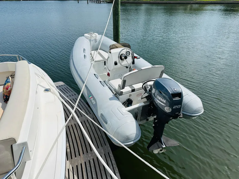 Slide: The Image of A 2014 Grand Banks 46 Eastbay SX with a Yamaha 20 outboard motor docked on calm water. - 4