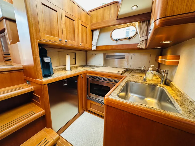 Slide: The Image of Luxurious 2014 Grand Banks 46 Eastbay SX yacht kitchen with wood cabinetry and modern appliances. - 40
