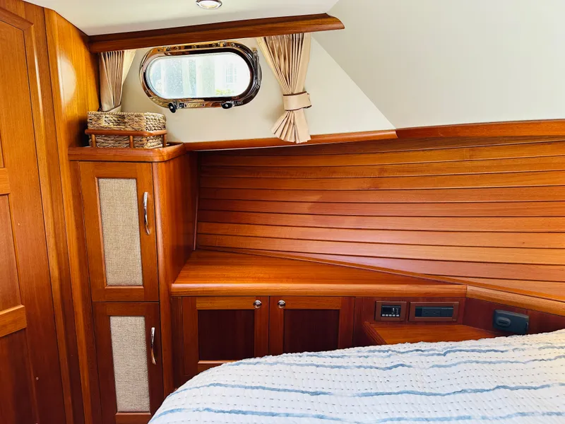 Slide: The Image of Interior of 2014 Grand Banks 46 Eastbay SX with wooden cabinetry and cozy bedding. - 45