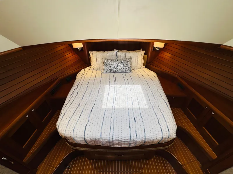 Slide: The Image of 2014 Grand Banks 46 Eastbay SX cabin with cozy bed and wooden interior. - 46